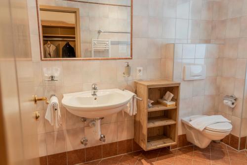 因斯布鲁克Sweet Cherry - Boutique & Guesthouse Tyrol的一间带水槽、卫生间和镜子的浴室
