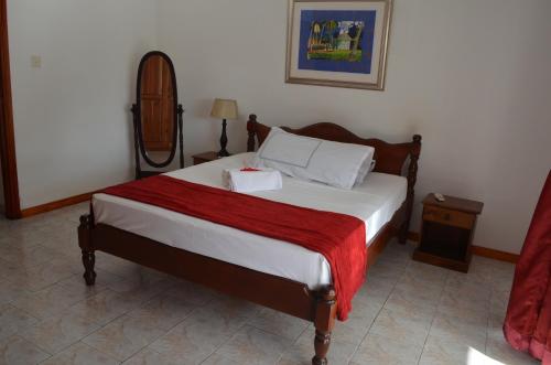 Pointe Larue托施顿别墅的一间卧室配有一张带红色毯子的床