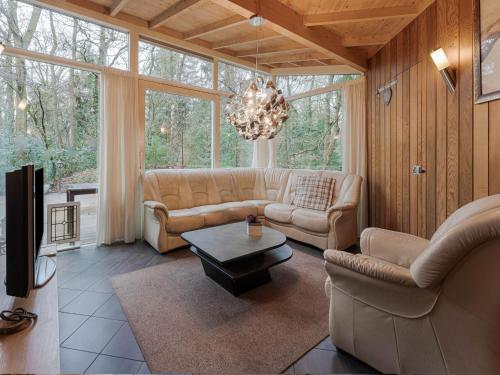 诺格Idyllically located Holiday Home in Norg with Sauna的带沙发和吊灯的客厅