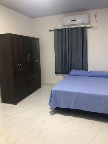 马瑙斯Apartamento bem localizado na Av.Principal的一间卧室配有一张床和一个带蓝色毯子的梳妆台。