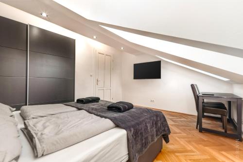 维也纳Designer Apartments, 2 min to U1 Reumannplatz的一间卧室配有一张床、一张书桌和一台电视。
