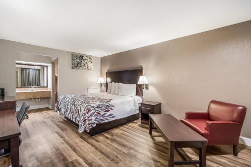 萨姆特Red Roof Inn Sumter的酒店客房配有一张床、一张桌子和一把椅子。