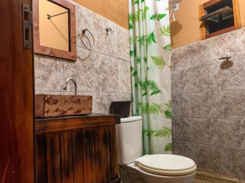 伦索伊斯Pousada Aconchego - Suítes Rústicas e Privativas的一间带卫生间和水槽的浴室