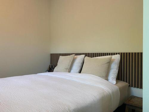 诺德韦克Northgo apartment的一间卧室配有带白色床单和枕头的床。