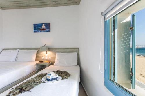 圣斯特凡诺斯Meltemi apartment by opus的一间卧室设有两张床和一个海滩窗口