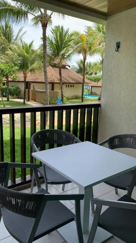 嘎林海斯港Marulhos Resort的棕榈树阳台的白色桌椅