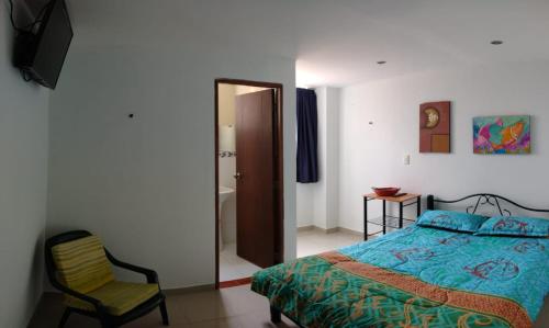 TocancipáCórest Hotel B&B的一间卧室配有一张床、一把椅子和镜子