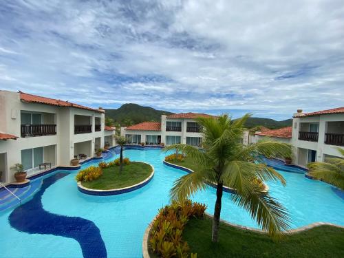 布希奥斯Buzios Beach Resort Super Luxo Residencial 2501 e 2502的享有棕榈树度假村游泳池的空中景致