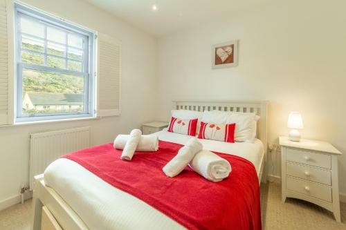 波斯陶恩Spring Tide的卧室配有红色和白色的床,提供毛巾