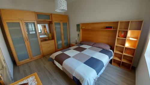 KerċemTrilogy, Ample Penthouse, Gozo的一间卧室配有一张大床和木制橱柜。