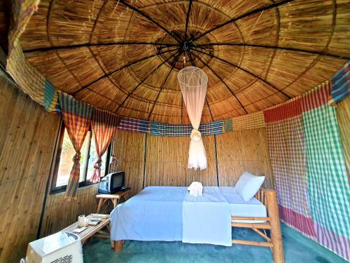 巴真府Saengcha Farm Resort的一张位于带大型木制天花板的房间内的床铺