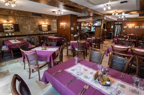 特里亚夫纳福美来家庭酒店的一间用餐室,配有紫色的桌子和椅子