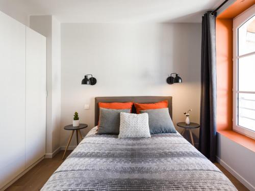 里尔Hyper centre chambre au calme的一间卧室配有一张大床,提供橙色和灰色的枕头