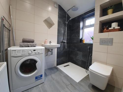 卢顿Victorian Home, 3BR, Airport, M1, 6 beds, sleeps 12的一间带洗衣机和水槽的浴室