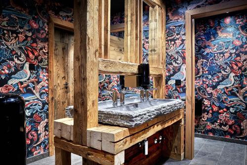 上陶恩佩内尔阿尔卑斯酒店的木墙内带石水槽的浴室