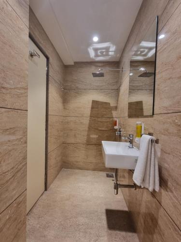 苏拉特Hotel El Magnifico的一间带水槽和镜子的浴室