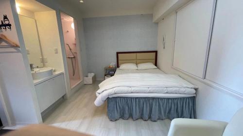 东京HotelHarmony日暮里ホテルハーモニー的一间卧室配有床和水槽,还有一间浴室