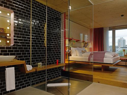 苏黎世霍普巴恩霍夫25小时酒店的浴室设有床铺和玻璃淋浴间。