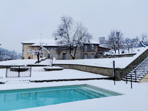 CeresetoAgriturismo Airale的一座房子前面的雪覆盖的游泳池
