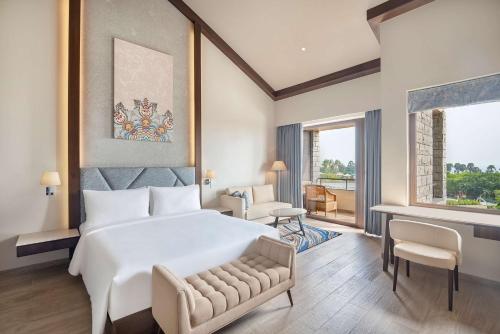 维沙卡帕特南Radisson Blu Resort Visakhapatnam的卧室设有一张白色大床和一扇窗户。