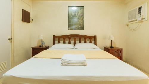 马尼拉Casa Micarosa Hotel and Residences by RedDoorz的一间卧室配有一张带2个床头柜的大型白色床