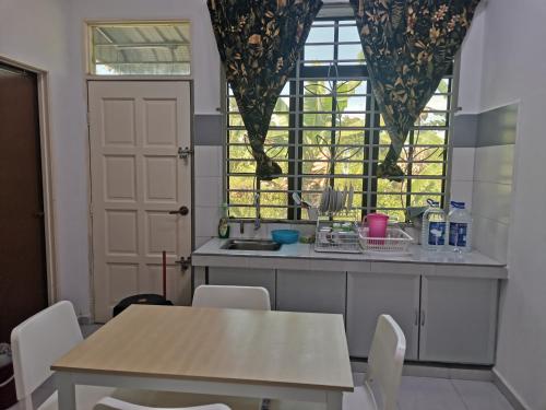 哥打巴鲁Homestay Pasir Tumboh Kota Bharu的厨房配有桌椅和窗户。