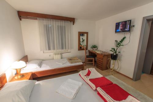 苏沙尼Vila Castello的一间卧室配有两张床和一张带窗户的书桌。