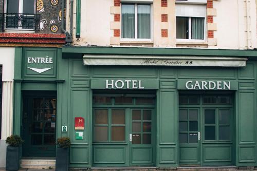 雷恩Garden Hotel Rennes Centre Gare的城市街道上的酒店绿色外墙