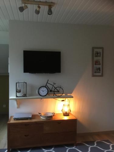 卡尔姆特豪特't Greefsch Geluck的客厅设有电视,墙上挂着白色的时钟