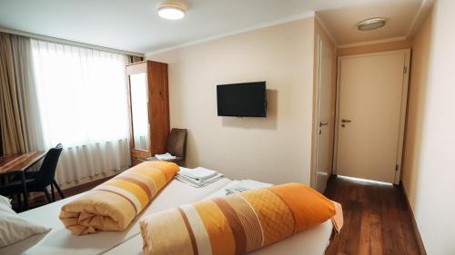 Bischofszell三同盟旅馆的酒店客房设有两张床和电视。