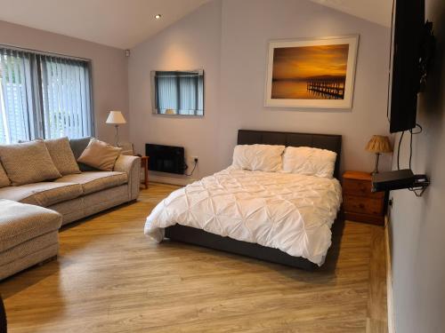WilpshireDean Clough Lodge - Contemporary self contained studio的一间卧室配有一张床和一张沙发