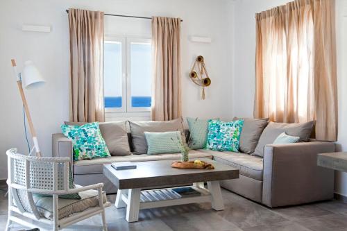 米克诺斯城Amperian Mykonos Suites & Villas的客厅配有沙发和桌子