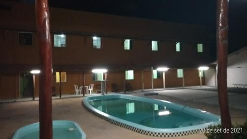 拜肖角落蓝色泻湖旅馆的一座空的游泳池,晚上在建筑物里