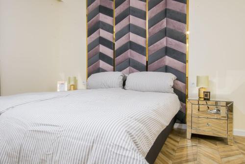 戈莱纽夫Central Apartments Goleniow Luxury的一间卧室设有一张带条纹墙的大床