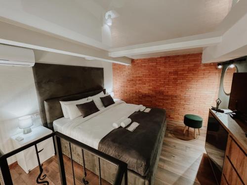 第比利斯Luxury Duplex Suites - City Center的一间卧室设有一张床和砖墙