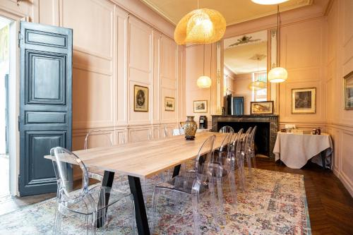 勒芒Le Henri IV的大型用餐室配有长桌和椅子