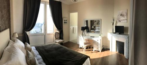 勒法韦La Maison de Louisette的一间卧室配有一张床、一张书桌和一面镜子