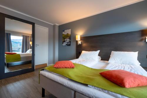 莫吕Thon Partner Hotel Måløy的一间卧室配有一张大床和大镜子