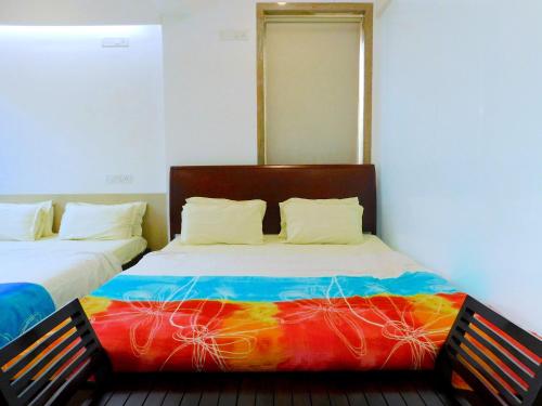 孟买Apartment In Mumbai City Centre的一间卧室配有两张床和彩色毯子