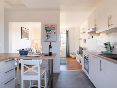 盖塔里Apartment Errepira by Interhome的厨房配有白色橱柜和一张带白色凳子的桌子
