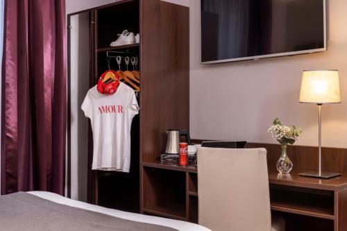 巴黎间奏曲酒店的酒店客房的衣柜上挂着一张床和衬衫