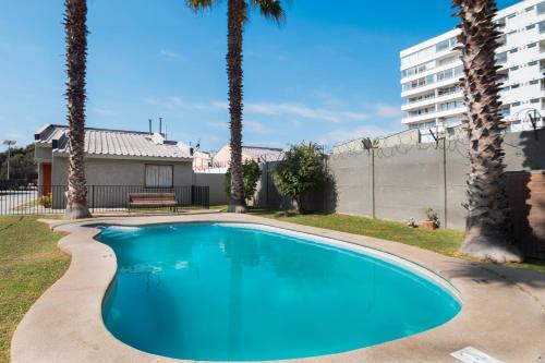 拉塞雷纳坎帕纳里奥德尔马酒店的一座棕榈树游泳池和一座建筑