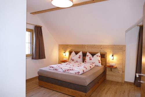 WeisspriachFerienhaus Weißpriach的一间卧室配有一张带红色枕头的大床