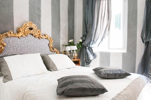 阿雷佐BIBI BOUTIQUE AREZZO Cartazucchero - Cioccolato的一间卧室配有一张带两个枕头的床