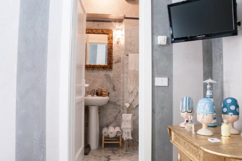阿雷佐BIBI BOUTIQUE AREZZO Cartazucchero - Cioccolato的一间带水槽的浴室和墙上的电视