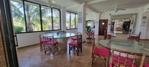 Monte GordoHotel Taboga Eco Boutique & Spa Costa Esmeralda的客房设有2张桌子和椅子以及窗户。