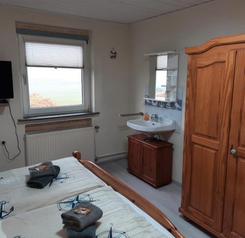 诺德代希Gästehaus Mia的一间卧室设有两张单人床和一个水槽