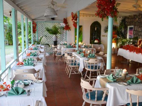 尼维斯欧瓦丽海滩度假酒店的一间设有白色桌椅的用餐室