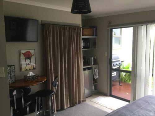科灵伍德Sunrise suite的卧室设有滑动玻璃门,可通往庭院。