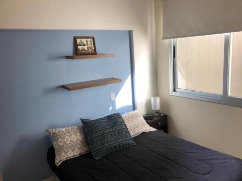 布宜诺斯艾利斯Cozy Apartment in Nuñez的一间卧室配有一张黑色床和窗户